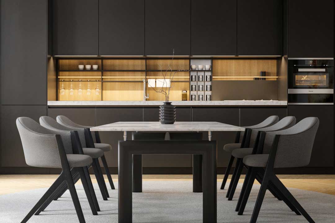 A modern rectangular white Carrara marble table in front of a sleek black panel kitchen with a beige backsplash.